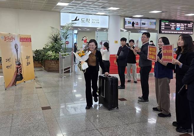 울산공업축제와 울산 관광을 위해 16일 중국남방항공 여객기를 타고 울산에 도착한 한 광저우 시민이 울산시 관계자로부터 환영 꽃다발을 받아들고 들어오고 있다. 울산시 제공