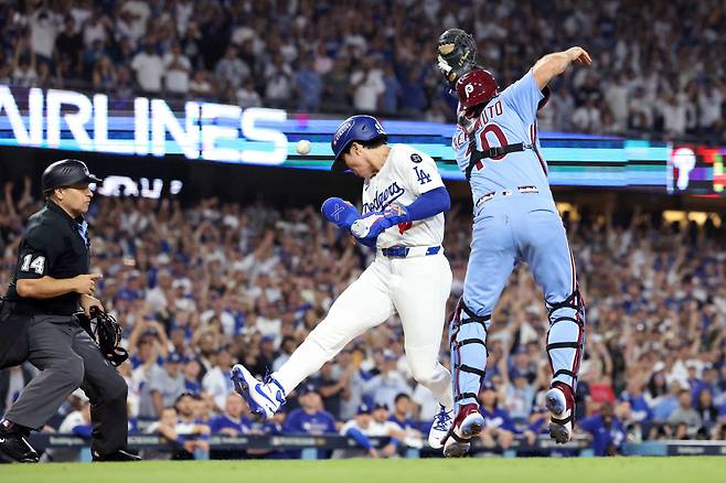 김혜성이 지난 10일(한국시각) 필라델피아와의 디비전시리즈 4차전서 연장 11회 대주자로 나간 뒤 앤디 파헤스의 땅볼을 잡은 상대 투수 오라이온 커커링의 실책 때 홈을 파고들어 끝내기 득점을 올리고 있다. AFP연합뉴스