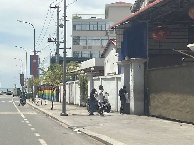 17일 캄보디아 남부 해안도시 시아누크빌 내 한 웬치(범죄단지)의 정문에서 배달 기사들이 대기하고 있다. 사진=김준석 특파원