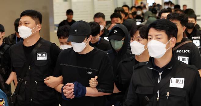 캄보디아 당국의 범죄단지 단속으로 적발돼 구금됐던 한국인들이 18일 오전 인천국제공항 2터미널을 통해 송환되고 있다. 이번 송환 대상자들은 이른바 '웬치'로 불리는 캄보디아 범죄단지에서 보이스피싱이나 로맨스 스캠(사기) 등 범죄에 가담한 혐의를 받고 있다. 이들은 호송 차량 23대 등을 타고 충남경찰청 등 6개 관할 경찰관서로 압송된다./사진=뉴스1