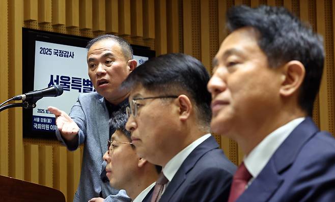 정치 브로커 명태균 씨가 23일 서울 중구 서울시청에서 열린 2025년 국회 행정안전위원회 국정감사에서 의원 질의에 답하고 있다. 오른쪽은 오세훈 서울시장. 연합뉴스