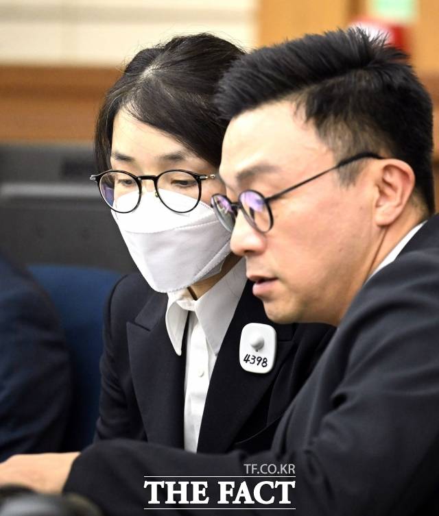 도이치모터스 주가조작 혐의와 통일교 금품수수 의혹 등 혐의를 받는 김건희 여사가 지난달 24일 첫 재판에 출석해 변호인과 대화하고 있다./사진공동취재단