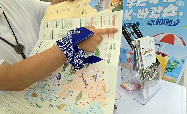경상북도 부스 담당자가 캠핑 지도를 가리키고 있다.
