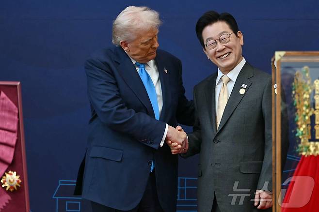 이재명 대통령이 29일 경북 경주박물관에서 열린 한미 공식 환영식에서 도널드 트럼프 미국 대통령에게 무궁화 대훈장을 수여한 후 악수를 하고 있다. 2025.10.29 ⓒ AFP=뉴스1 ⓒ News1 김경민 기자