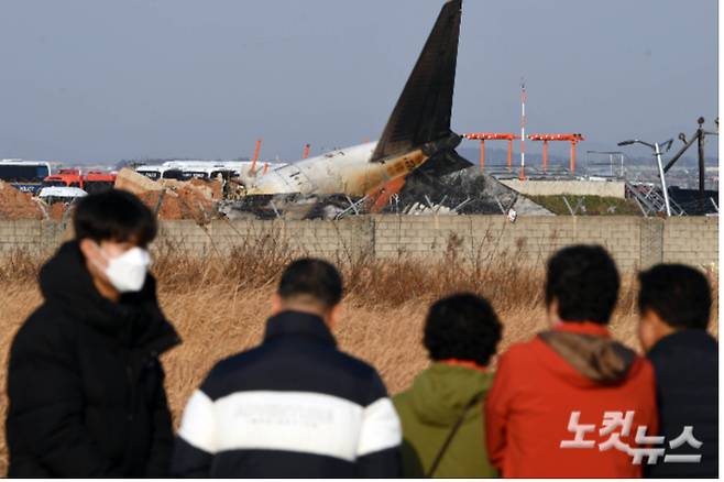 지난해 12월 29일 전남 무안국제공항에서 탑승객 181명을 태운 여객기가 착륙 중에 사고가 났다. 주민들은 사고 현장을 바라보고 있다. 황진환 기자