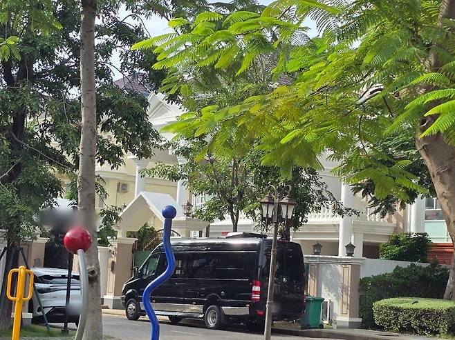 한국 청년들이 갇혀있는 것으로 추정되는 캄보디아 프놈펜의 한 고급주택 앞에 소형버스 등이 주차돼있다. 사진=연합뉴스