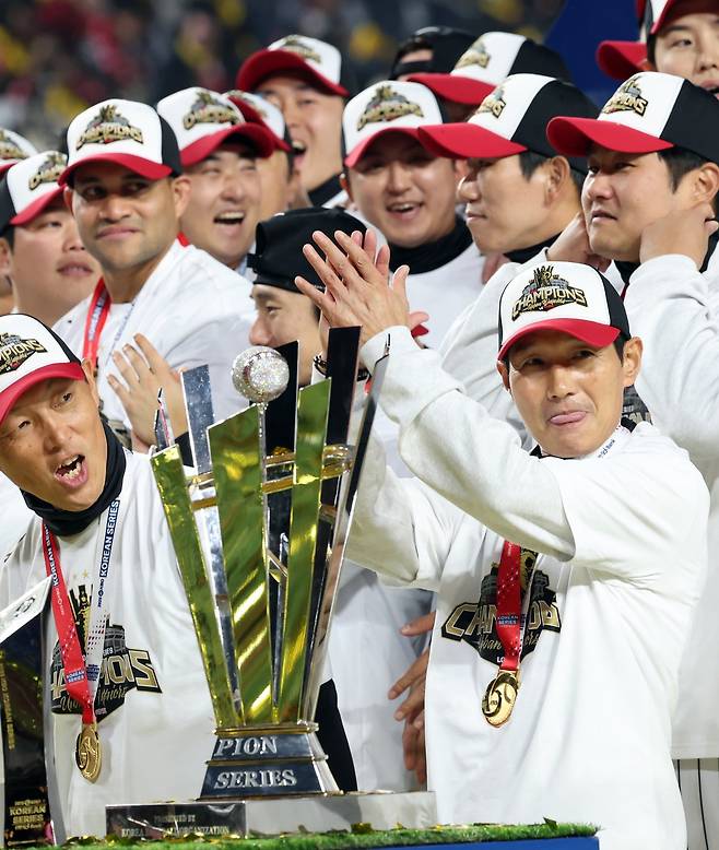 LG 염경엽 감독(오른쪽 앞)이 31일 대전한화생명볼파크에서 열린 ‘2025 신한 SOL 뱅크 KBO PS’ 한화와 한국시리즈 5차전에서 4-1로 이겨 통합우승을 확정한 뒤 트로피 옆에서 박수를 치고 있다. 대전|뉴시스