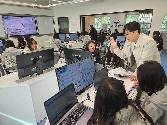 목포항도여중 ‘2030꿈터 AI교실’에서 진행된 ‘생활 속 디지털 음악교육&디지털 도구 활용 표현창작’ 수업에서 박준 리더교사가 학생들과 의견을 나누고 있다./박선옥 기자