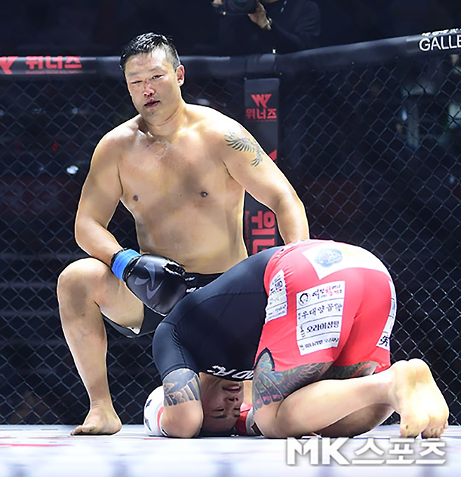 제8대 로드FC 미들급 챔피언 황인수가 2023년 2월 경기도 고양체육관 킥복싱 메인이벤트 관중 6946명이 보는 앞에서 대한민국 입식타격기 무제한급 최강자 명현만을 꺾은 후 절을 하며 선배에게 예의를 차리고 있다. 사진=김영구 기자