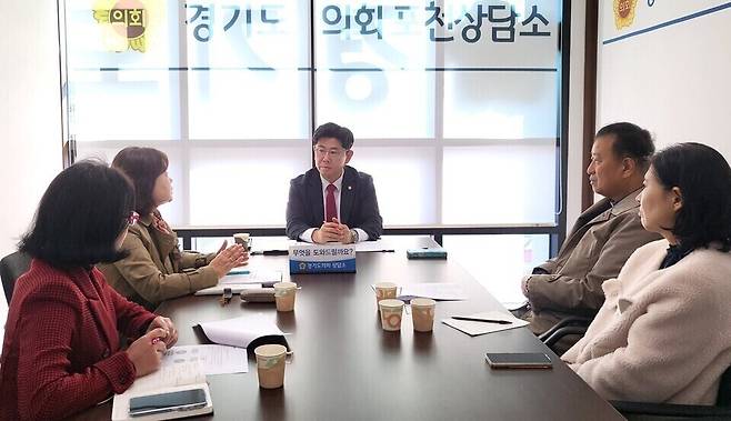 ▲ 재가 노인 지원 서비스 관계자들이 경기도의 도비 지원 중단 방침 철회를 요구하며 윤충식 도의원을 만나 의견을 전달하고 있다. /사진제공=경기도의회