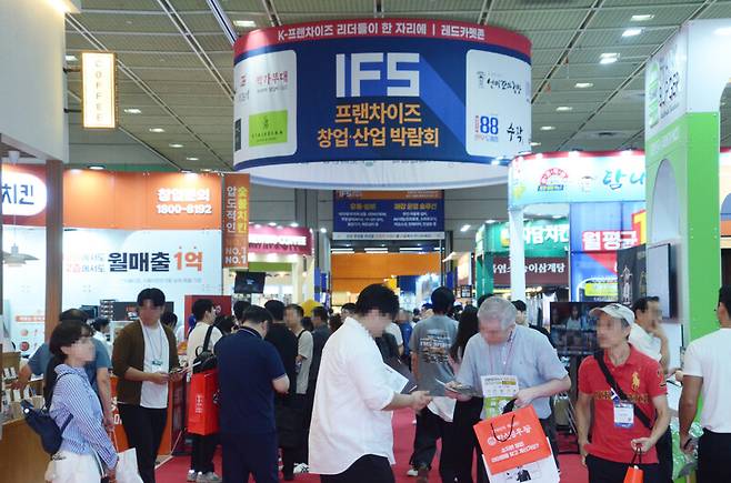 2025년 9월 한국프랜차이즈산업협회가 주최한 2025년 하반기 프랜차이즈 창업·산업 박람회에서 참가자들이 부스를 돌아보고 있다. 가맹본사와 가맹점주 사이 갈등이 격화하는 와중에도 프랜차이즈 창업에 대한 서민들의 관심은 뜨겁다. 한국프랜차이즈산업협회 제공