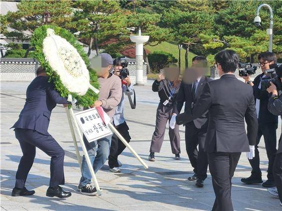 장동혁 국민의힘 당 대표가 6일 오후 3시50분쯤 광주를 찾아 국립 5·18민주묘지를 참배하기 위해 추모의 문 앞에 도착하기 직전 광주전남촛불행동 회원들이 당 대표 조화를 치우고 있다. 이 과정에서 국민의힘 관계자와 촛불행동 회원 간 '뺏고 빼앗기는' 격렬한 몸싸움이 벌어졌다. ⓒ 시사저널 정성환
