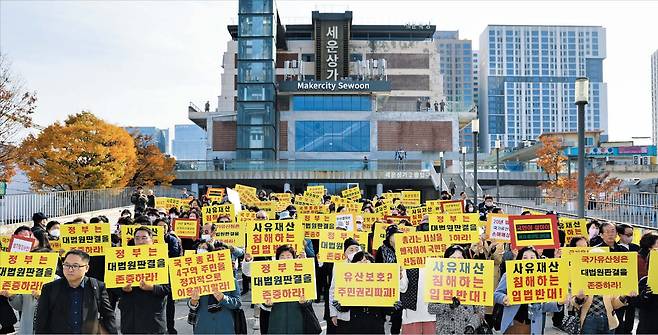 주민들, 세운상가 앞 기자회견 서울 종로구 세운4구역 주민들이 11일 세운상가에서 기자회견을 열고 있다. ‘정부는 대법원 판결을 존중하라’ ‘사유재산 침해하는 입법 반대’라고 쓴 플래카드를 들었다./박성원 기자