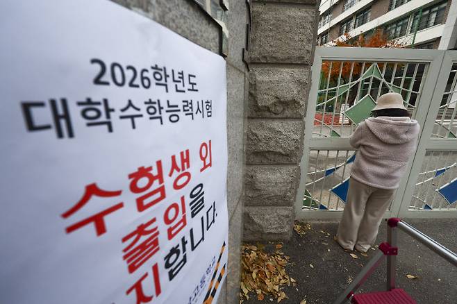 2026학년도 대학수학능력시험날인 13일 서울 광진구 광남고등학교 교문 앞에서 한 수험생 학부모가 기도를 하고 있다.(사진=뉴시스).