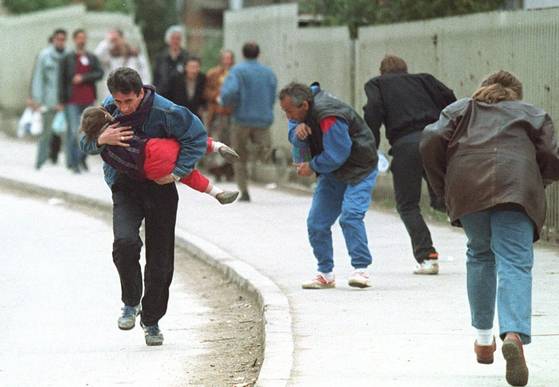 1993년 보스니아 내전 당시, 세르비아 저격수의 집중 사격을 피해 몸을 숙이고 사라예보 시내를 통과하는 시민들. AP연합뉴스