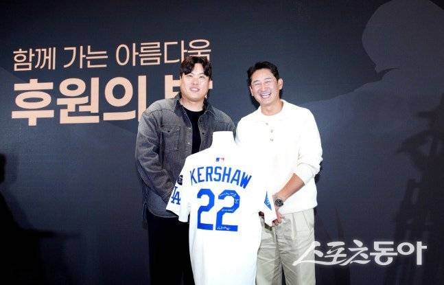 류현진(왼쪽)과 박용택 해설위원이 2800만 원에 낙찰된 클레이튼 커쇼 유니폼을 입고 포즈를 취하고 있다. 사진제공 | 류현진재단