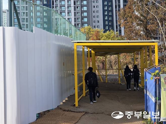 지난 17일 오후 광명시 철산동 현충지하차도 공사현장에 임시로 마련된 보행자 통로로 학생들이 이동하고 있다. 최진규기자