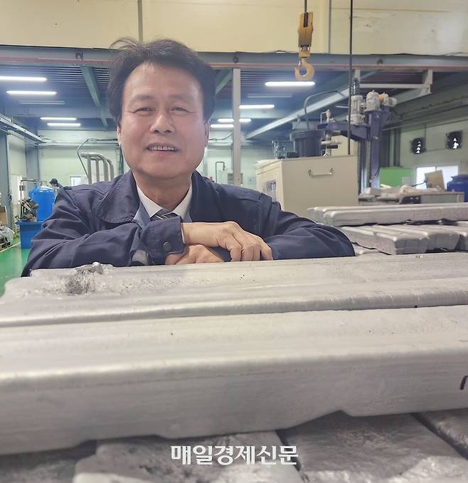 지에이엠 최진철 대표가 고강도 알루미늄 합금 잉곳 옆에서 말하고 있다. 이한나기자