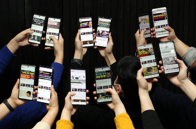 2020년 12월 조선일보 기자들이 스마트폰 12대를 이용해 유튜브의 정치 콘텐츠 알고리즘을 조사하고 있다. /이태경 기자