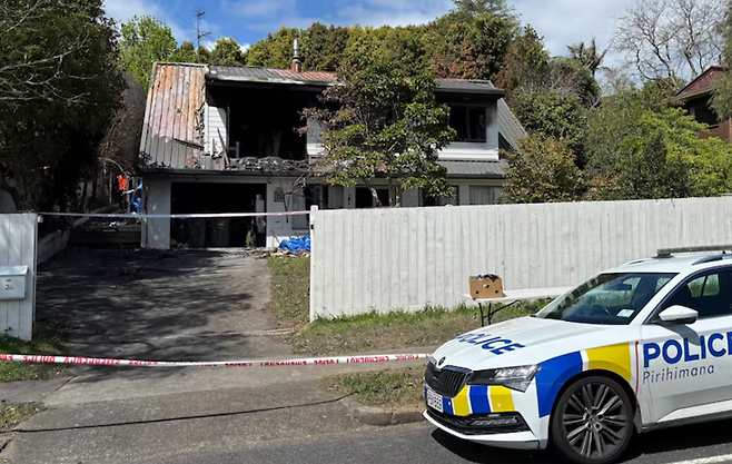 뉴질랜드 오클랜드 벅클랜즈비치에서 10월 2일 발생한 방화로 2명이 숨진 뒤 경찰이 심하게 훼손된 주택 주변에 통제선을 설치하고 수사를 진행하고 있다. X 캡처