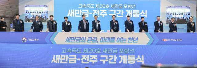 21일 새만금 고속도로 김제 휴계소에서 열린 고속국도 제20호 새만금 포항선 새만금-전주 구간 개통식에 김윤덕 국토부 장관과 김관영 전북도지사, 안호영·이원택 국회의원, 함진규 한국도로공사 사장, 김의겸 새만금개발청장, 김성주 김제시장, 유희태 완주군수, 문승우 전북도의장, 윤동욱 전주 부시장 등이 개통 퍼포먼스를 하고 있다./사진=전북도