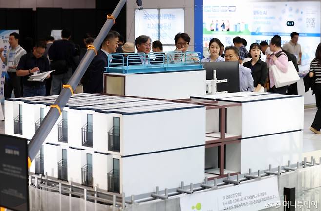(서울=뉴스1) 오대일 기자 = 30일 서울 강남구 코엑스에서 열린 ‘집코노미 박람회 2025’에서 방문객들이 LH가 세종스마트단지에 조성하는 국내 최대 모듈러 주택 단지 모형을 살펴보고 있다. 올해로 11회째를 맞는 집코노미 박람회는 국내 최대의 종합 부동산 박람회로 다음 달 1일까지 이틀간 코엑스 B홀에서 개최된다. 2025.9.30/뉴스1 Copyright (C) 뉴스1. All rights reserved. 무단 전재 및 재배포, AI학습 이용 금지. /사진=(서울=뉴스1) 오대일 기자