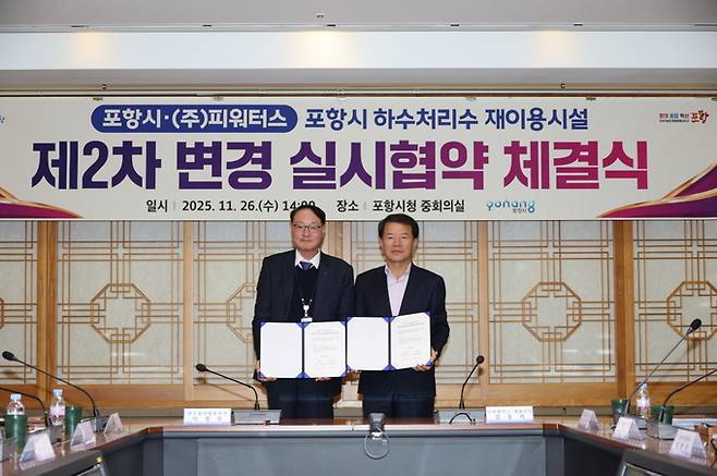 ▲ 이창우 포항시 맑은물사업본부장(사진 왼쪽)과 김동기 ㈜ 피워터스 대표가 26일 하수처리수재이용시설 민간투자사업의 안정적 운영 기반을 강화하기 위한 제2차 변경 실시협약을 체결한 뒤 협약서를 들고 기념 촬영하고 있다.