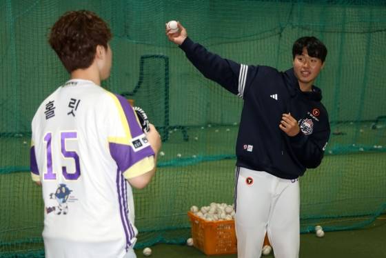 홍민규(오른쪽)가 지난 5월 6일 잠실 LG 트윈스전에 시구자로 나선 브롤스타즈 크리에이터 홀릿에게 투구하는 동작을 가르쳐주고 있다. /사진=두산 베어스 제공
