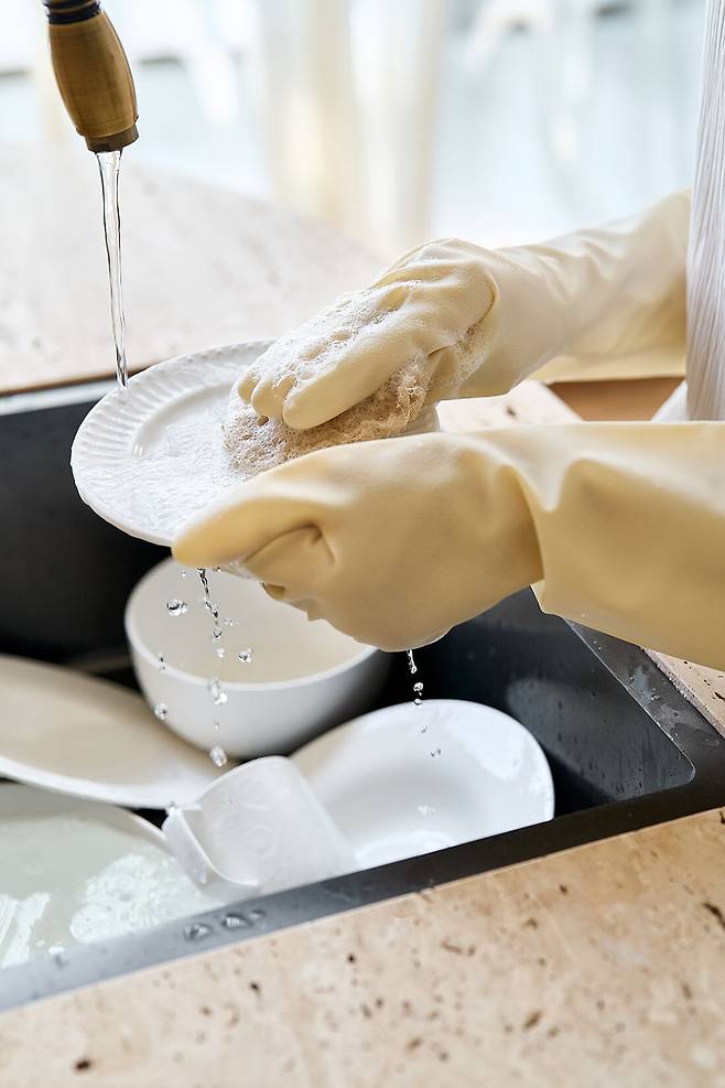 주방세제와 물 노출을 줄이기 위해 고무장갑을 착용한 채 설거지를 하는 모습. 게티이미지뱅크