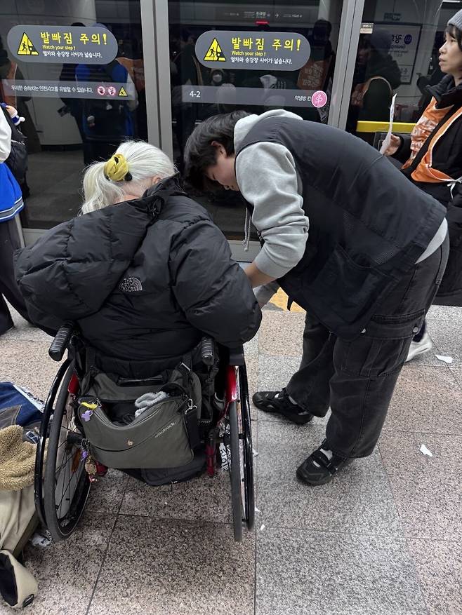 지난 11월18일 서울 지하철 광화문역에서 열린 전국장애인차별철폐연대(전장연)의 ‘66차 출근길 지하철 탑니다’ 시위에서 문가빈씨(오른쪽)가 박경석 전장연 대표의 휠체어를 손보고 있다. 김효실 기자 trans@hani.co.kr