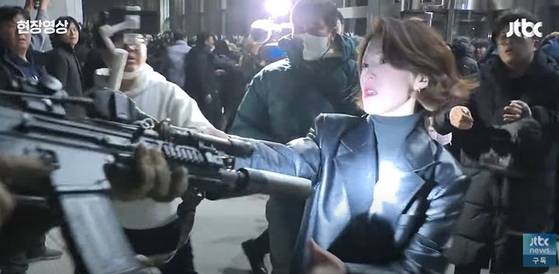 지난해 12월3일 안귀령 대통령실 부대변인(당시 더불어민주당 대변인)이 계엄군이 든 총을 손으로 막고 있다. 사진 JTBC 캡처