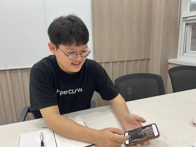 지난달 25일 강현씨(25)가 지난해 12월3일 비상계엄 사태 때 국회로 가 직접 촬영한 현장 사진을 보여주며 당시를 설명하고 있다. /사진=이정우 기자.