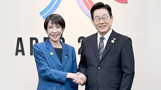 이재명 대통령이 지난 10월 30일 경북 경주에서 열린 APEC 정상회의에서 다카이치 사나에 일본 총리와 한·일본 정상회담에 앞서 악수를 나누는 모습. 다카이치 총리의 재킷에 납치된 일본인 피해자의 송환을 염원하는 블루리본이 달려있다. 대통령실사진기자단.