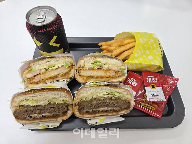 노브랜드 버거의 ‘NBB 어메이징 감바스 버거’와 ‘골든 카츠 버거’를 반으로 잘라 단면을 비교한 모습. (사진=한전진 기자)