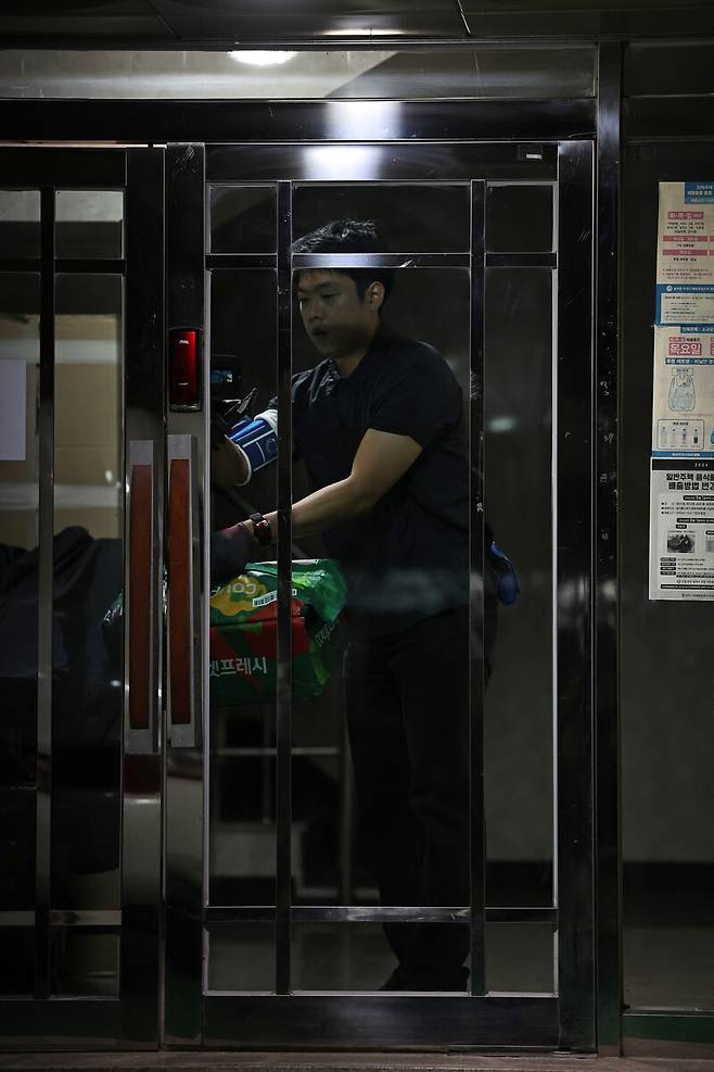 2025년 11월13일 서울 송파구에서 류석우 기자가 한 다세대주택에서 회수한 프레시백을 들고나오고 있다. 이 주택의 공동현관문 외부 센서등은 반응이 늦어, 건물 안으로 들어갈 때 문턱 등이 잘 보이지 않았다. 이종근 선임기자 root2@hani.co.kr