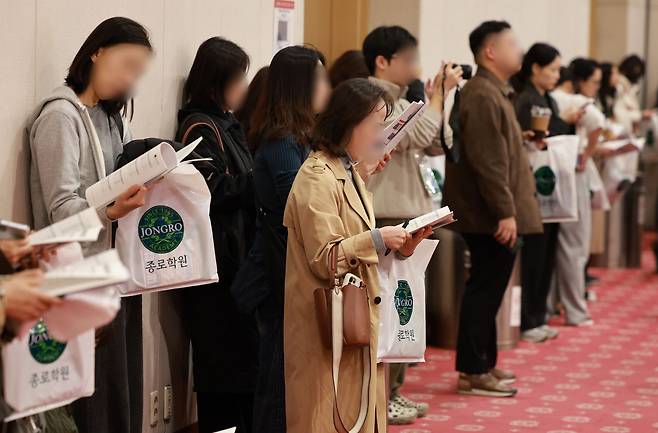 Parents stand at a consulting session held by a private academy in Seoul on Nov. 14. (Yonhap)