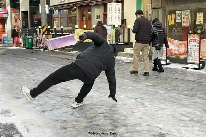 2025년 12월 첫눈 다음 날 낮 1시 무렵, 광화문 인근 얼어붙은 도로에서 한 중년 남성이 미끄러져 넘어지고 있다. 필자 역시 바로 직전에 빙판에 미끄러져 이 위험한 상황을 기록했다. 일어나지 못하면 119를 부르려 했으나, 그는 다행히 스스로 일어났다. 포토저널리스트의 책임은 눈앞의 현실을 객관적으로 기록하는 데 있다. 2025년 12월 5일 강형원 촬영