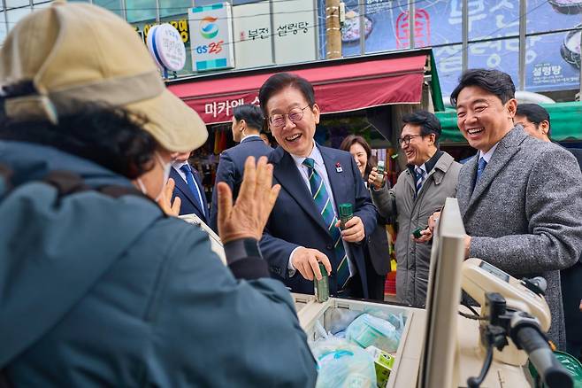 이재명 대통령이 23일 부산 진구 부전시장을 찾아 상인들과 대화하고 있다. 대통령실 제공