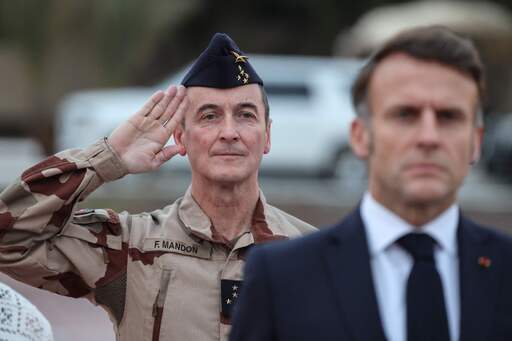 지난 21일 아랍에미리트(UAE)에 있는 프랑스군 기지를 방문한 에마뉘엘 마크롱 프랑스 대통령(오른쪽)과 파비앙 망동 국방참모총장(공군 대장)이 장병들을 사열하고 있다. 불안한 프랑스 국내 정치 상황 때문인지 마크롱의 표정이 어두워 보인다. AFP연합뉴스