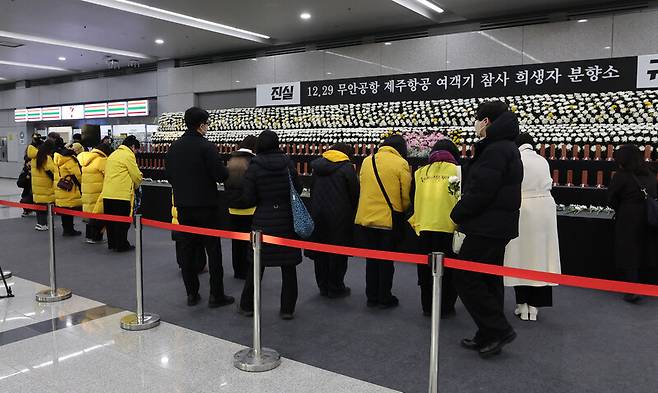 세월호 참사 유가족들이 29일 오전 전남 무안군 무안국제공항에서 열린 1주기 추도식에 참석하기 전 희생자 분향소에 방문해 헌화한 뒤 묵념하고 있다. 백소아 기자 thanks@hani.co.kr