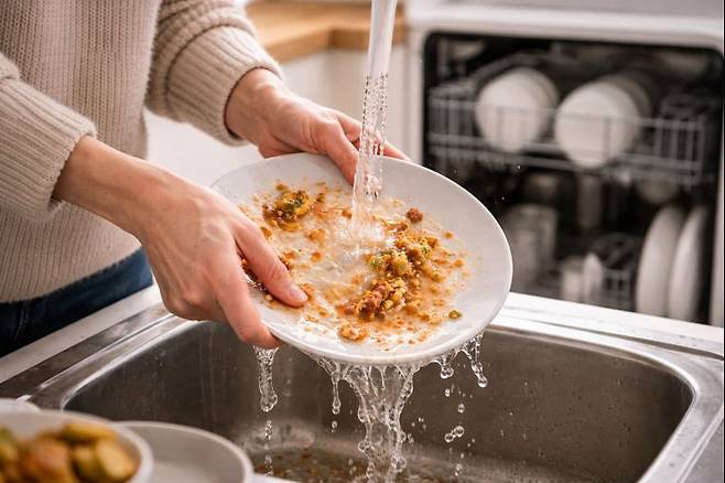 접시를 물로 씻고 있는 모습