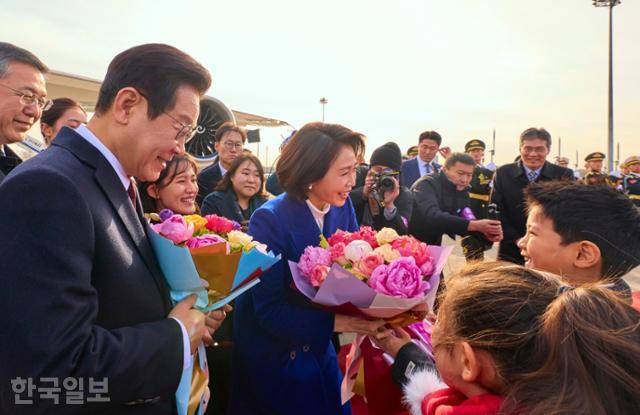 이재명 대통령과 김헤경 여사가 4일 중국 국빈방문을 위해 베이징 서우두 공항 도착해 화동들에게 꽃을 받고 있다. 베이징=왕태석 선임기자