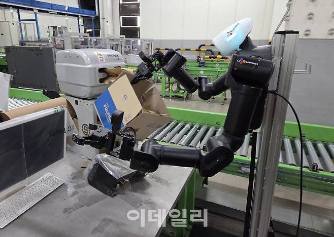 CJ대한통운 군포센터에서 양팔 휴머노이드 로봇이 박스에 완충재를 넣고 있다. (사진=한전진 기자)