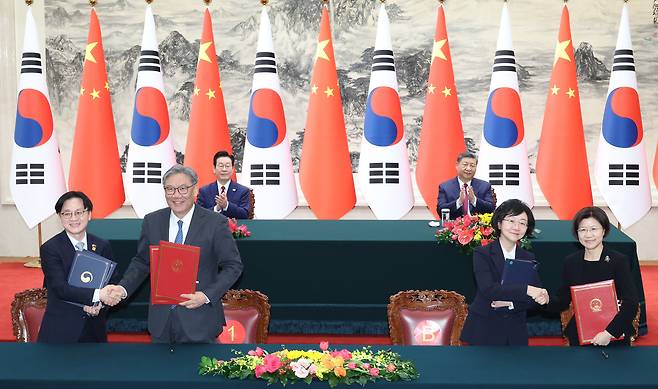 Front row, from left: South Korean Industry Minister Kim Jung-kwan, Chinese Commerce Minister Wang Wentao, South Korean Food and Drug Safety Minister Oh Yu-kyoung, and Sun Meijun, director general of China's General Administration of Customs, attend signing ceremonies for agreements on the establishment of a commercial cooperation dialogue and on food safety cooperation, respectively, at the Great Hall of the People in Beijing on Monday. (Yonhap)