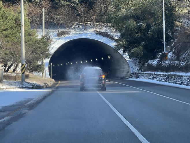 12일 광주 서구 화정동 짚봉터널에서 한 차량이 눈이나 비가 얼어붙어 형성된 블랙아이스 구간을 주행하고 있다. /박건우 기자