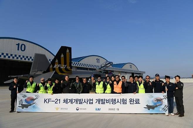 Test pilots and officials pose for a photo in front of the KF-21 prototype during a ceremony commemorating the completion of its final development flight tests on Monday in Sacheon, South Gyeongsang Province. (Defense Acquisition Program Administration)