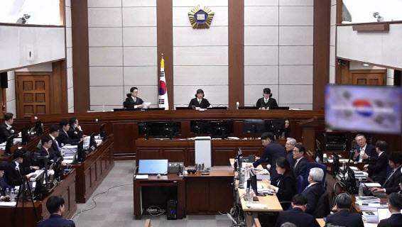 윤석열 전 대통령이 13일 오후 서울 서초구 서울중앙지방법원에서 진행된 내란 우두머리 혐의 2차 결심공판에 출석해 자리에 앉아 윤갑급 변호사와 대화를 하고 있다.(사진=서울중앙지법)