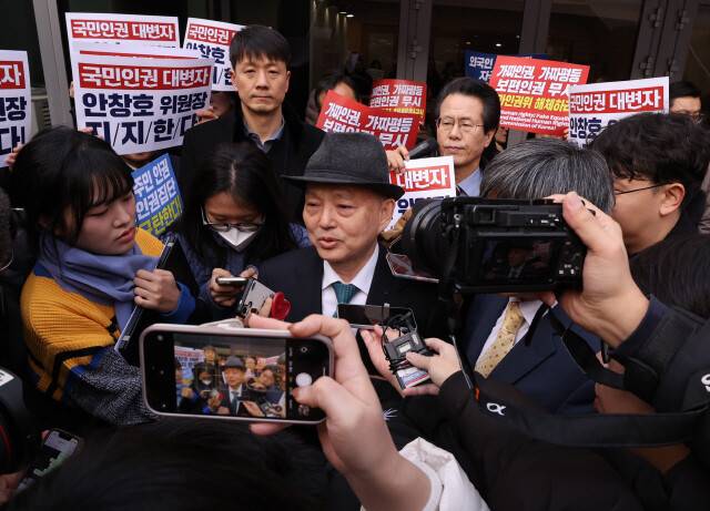 안창호 국가인권위원회 위원장이 10일 오전 서울 중구 안중근의사기념관에서 진행되는 2025 인권의 날 기념식장 앞에서 인권위바로잡기공동행동(공동행동) 등 사퇴를 촉구하는 시민단체에 의해 입장이 저지된 뒤 기자들에 둘러싸여 있다. 공동취재사진