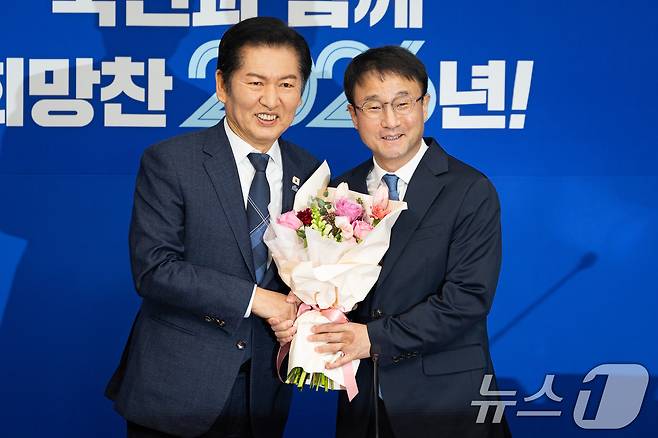 정청래 더불어민주당 대표와 한병도 신임 원내대표가 지난 12일 서울 여의도 국회에서 열린 최고위원회의에 앞서 꽃다발을 들고 기념 촬영을 하고 있다. 2026.1.12/뉴스1 ⓒ News1 유승관 기자