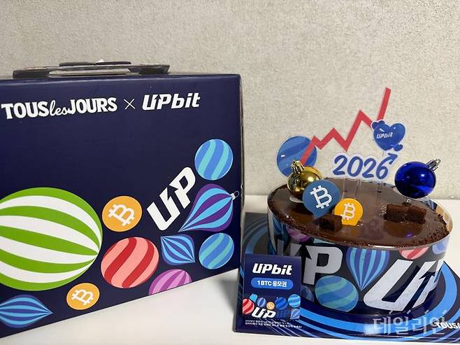 '2026 업비트 위시 케이크' 상단에 장식된 우상향 그래프 토퍼와 비트코인 로고 초콜릿. ⓒ데일리안 황지현 기자